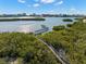 Scenic aerial view of a wooden boardwalk surrounded by lush greenery overlooking the waterfront at 14584 El Paseo Dr, Seminole, FL 33776