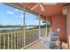 Relaxing screened balcony with ceiling fan and blue Adirondack chairs offers beautiful waterfront views at 14584 El Paseo Dr, Seminole, FL 33776