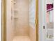 An updated bathroom with a standing shower, a glass block window, and neutral-colored tile throughout at 14584 El Paseo Dr, Seminole, FL 33776