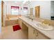 Spacious bathroom featuring dual sinks, a vanity, a tub, and a window at 14584 El Paseo Dr, Seminole, FL 33776