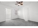 Cozy bedroom with soft carpet, ceiling fan, and walk-in closet offers a tranquil retreat at 14584 El Paseo Dr, Seminole, FL 33776