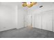 Bright bedroom with neutral walls, gray carpet, ceiling fan, and closet space at 14584 El Paseo Dr, Seminole, FL 33776