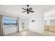 Bright bedroom with a ceiling fan, large window with a view, balcony access, and an en-suite bathroom at 14584 El Paseo Dr, Seminole, FL 33776