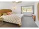 Cozy bedroom with a wicker bed frame, a ceiling fan, and a large window at 14584 El Paseo Dr, Seminole, FL 33776