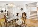 Bright dining room featuring a glass table, staircase, and stylish coastal decor accents at 14584 El Paseo Dr, Seminole, FL 33776