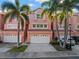 Charming townhouse with a two-car garage, mature palm trees, and a well-maintained lawn at 14584 El Paseo Dr, Seminole, FL 33776