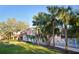 Beautiful home showcases mature palm trees, lush lawn, and white picket fence at 14584 El Paseo Dr, Seminole, FL 33776