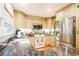 Well-lit kitchen features a modern stainless steel refrigerator, granite countertops, and light colored cabinets at 14584 El Paseo Dr, Seminole, FL 33776