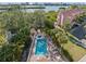 Community pool surrounded by lush landscaping, tables and chairs at 14584 El Paseo Dr, Seminole, FL 33776