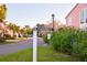 El Paseo Drive street sign in a condo community with lush tropical landscaping and pink exterior at 14584 El Paseo Dr, Seminole, FL 33776