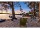 A serene backyard beach featuring relaxing lounge furniture, sandy shore, and waterfront views at 19242 Blount Rd, Lutz, FL 33558