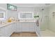 Well-lit bathroom features a double sink vanity, large mirror, and glass shower with rainfall shower head at 19242 Blount Rd, Lutz, FL 33558