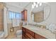 Well-lit bathroom featuring granite counters, tile surround, and a shower-tub combo for relaxation and comfort at 19242 Blount Rd, Lutz, FL 33558