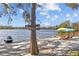 Private beach with jet ski, kayak, and chairs with umbrellas overlooking the lake at 19242 Blount Rd, Lutz, FL 33558