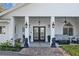 Elegant covered front entry featuring stately columns, double doors, and meticulous landscaping for an inviting approach at 19242 Blount Rd, Lutz, FL 33558