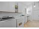 Functional laundry room with ample storage, modern appliances, and white cabinets at 19242 Blount Rd, Lutz, FL 33558