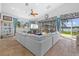 Open-concept living room featuring a large sectional, travertine floors and waterfront views at 19242 Blount Rd, Lutz, FL 33558