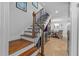 Elegant staircase features wooden steps, iron railing, and leads to an open area with views of the dining room at 19242 Blount Rd, Lutz, FL 33558
