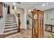This home's foyer features tile floors, a wooden staircase, a grandfather clock, and neutral wall colors at 227 126Th Ave, Treasure Island, FL 33706