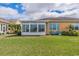 Well-maintained backyard with sunroom, lush lawn, and chairs for outdoor relaxation at 2313 Nottingham Greens Dr # 2313, Sun City Center, FL 33573