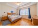 Inviting bedroom with hardwood floors, tray ceiling, large window, and classic wooden furnishings at 2313 Nottingham Greens Dr # 2313, Sun City Center, FL 33573