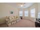 Bedroom featuring a ceiling fan, windows with blinds, and a comfortable floral sofa at 2313 Nottingham Greens Dr # 2313, Sun City Center, FL 33573