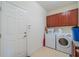 Functional laundry room featuring upper cabinets, a washer, dryer, and a granite countertop for folding at 2313 Nottingham Greens Dr # 2313, Sun City Center, FL 33573