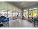 Bright sunroom with tile flooring, ceiling fan, and windows overlooking water views at 2313 Nottingham Greens Dr # 2313, Sun City Center, FL 33573