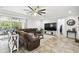 Bright living room with tile floors, sectional sofa, ceiling fan, and access to a sunroom at 23958 Terracina Ct, Land O Lakes, FL 34639