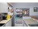 Kitchen view showcasing stainless steel refrigerator and sliding glass door to outdoor living area at 2612 6Th Ct, Palm Harbor, FL 34684