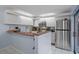 Bright kitchen featuring white cabinetry, stainless steel appliances, breakfast bar, and mosaic backsplash at 2612 6Th Ct, Palm Harbor, FL 34684