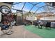 Spacious screened patio with outdoor seating, grill, surfboards, and bicycle at 2612 6Th Ct, Palm Harbor, FL 34684