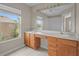 Light-filled bathroom featuring double sinks, wood cabinetry, and a large mirror for a spa-like feel at 2824 Conch Hollow Dr, Brandon, FL 33511