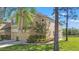 Attractive two-story townhome featuring a tan stucco exterior, lush landscaping, and attached garages at 2824 Conch Hollow Dr, Brandon, FL 33511