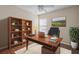 Bright home office with hardwood floors, large desk, and built-in bookshelf at 2824 Conch Hollow Dr, Brandon, FL 33511