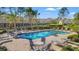 A community pool is surrounded by lush landscaping, lounge chairs, and tables on a sunny day at 2824 Conch Hollow Dr, Brandon, FL 33511