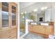 Modern bathroom with dual sinks, a glass-enclosed shower, and a stylish built in linen closet at 3018 N 164Th Pl, Clearwater, FL 33760