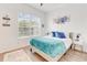 Bright bedroom featuring a comfortable bed, plush rug, and a large window for natural light at 3018 N 164Th Pl, Clearwater, FL 33760