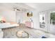 An open bedroom with gray floors, a bed, a pink dresser, and access to the outdoor deck at 3018 N 164Th Pl, Clearwater, FL 33760