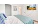 Cozy bedroom features a comfortable bed with white linens, blue pillows, and a flatscreen TV on the wall at 3018 N 164Th Pl, Clearwater, FL 33760
