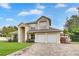 Charming two-story home with a brick driveway, three-car garage, and lush landscaping at 3018 N 164Th Pl, Clearwater, FL 33760