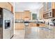 Spacious kitchen featuring stainless steel appliances, light wood cabinetry, and granite countertops at 3018 N 164Th Pl, Clearwater, FL 33760