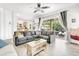 Open-concept living room with a kitchen view and a large sectional couch, plus patio access at 3018 N 164Th Pl, Clearwater, FL 33760