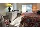 Comfortable bedroom with bright light, large dresser, and floral bedding at 3400 Gulf Blvd # 304, Belleair Beach, FL 33786