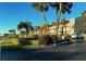 Exterior daytime view of condo complex with mature palm trees and attractive, manicured landscaping at 3400 Gulf Blvd # 304, Belleair Beach, FL 33786