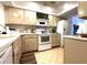 Functional kitchen featuring ample cabinet space, white appliances, and neutral countertops at 3400 Gulf Blvd # 304, Belleair Beach, FL 33786