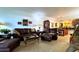 Spacious living room featuring a plush leather sofa, vintage decor, and a view into the dining area at 3400 Gulf Blvd # 304, Belleair Beach, FL 33786