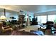 Cozy living room with comfortable leather furniture, mirrored wall, and access to the balcony at 3400 Gulf Blvd # 304, Belleair Beach, FL 33786