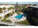 Inviting kidney-shaped pool surrounded by palm trees, white lounge chairs, and lush landscaping, perfect for relaxing and enjoying the outdoors at 3400 Gulf Blvd # 304, Belleair Beach, FL 33786