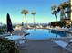 A sunny pool with lounge chairs offers an inviting space for relaxation with distant ocean views at 3400 Gulf Blvd # 304, Belleair Beach, FL 33786